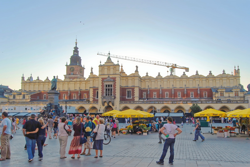 22 - The Main Market Square (Rynek Główny) in Kraków, Poland, featuring pedestrians on the cobblestone plaza next to the historic Church of St. Mary